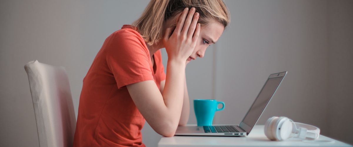 Woman sitting quietly, looking down — healing low self-worth